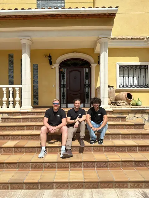 Equipo de DKZ Studio, productora audiovisual y agencia de marketing de Murcia, sentado en los escalones de una casa · DKZ Studio, Murcia