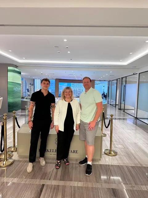 Three people pose in a hotel lobby during a work meeting with DKZ Studio · marketing and video agency for businesses in Churra