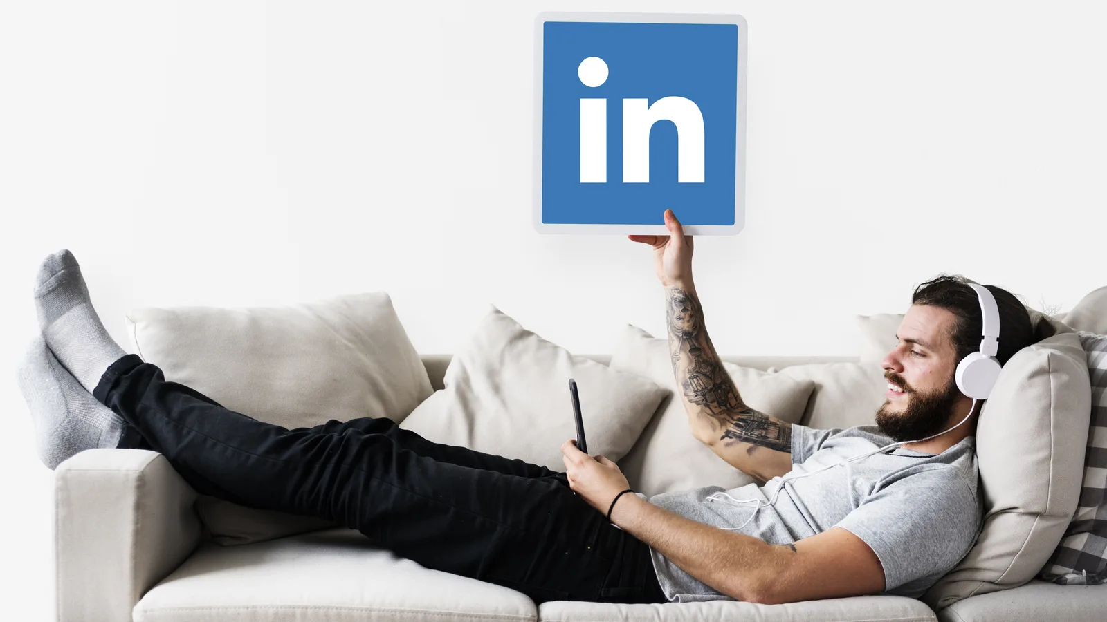Hombre con auriculares sosteniendo el logotipo de LinkedIn