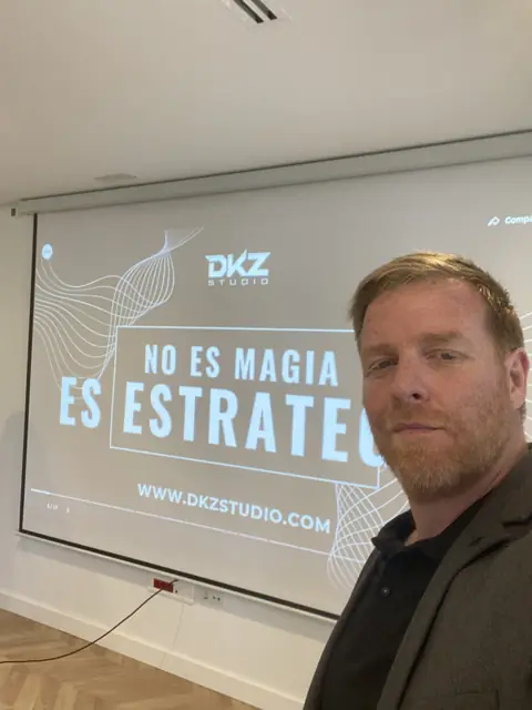 Pantalla con la frase «No es magia, es estrategia» y la web dkzstudio.com durante una charla de DKZ Studio · DKZ Studio, Murcia