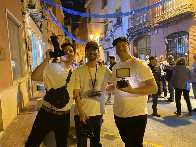Tres miembros del equipo de DKZ Studio con cámaras y luz led en un rodaje nocturno en una calle del casco antiguo · marketing y producción audiovisual para Almería