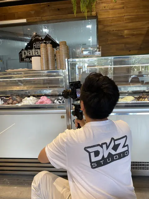 Videógrafo de DKZ Studio grabando con cámara estabilizada el mostrador de una heladería · DKZ Studio, Murcia